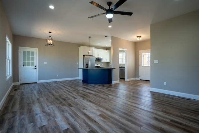 unfurnished living room with recessed lighting, baseboards, and dark wood-style flooring