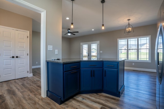 kitchen with blue cabinetry, baseboards, dark wood finished floors, and hanging light fixtures