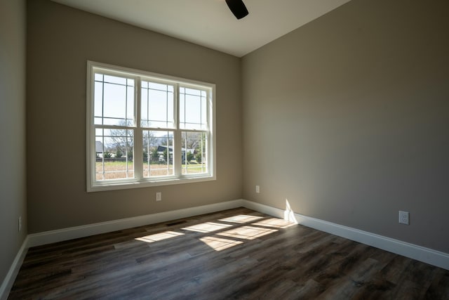 empty room with dark wood-type flooring, baseboards, and ceiling fan