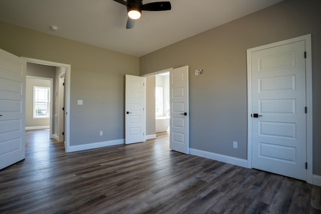 unfurnished bedroom with baseboards, dark wood-style floors, and a ceiling fan