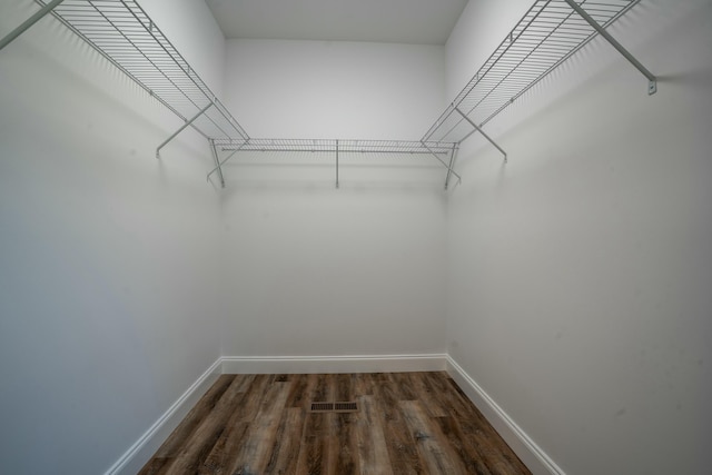 spacious closet featuring visible vents and dark wood-style floors