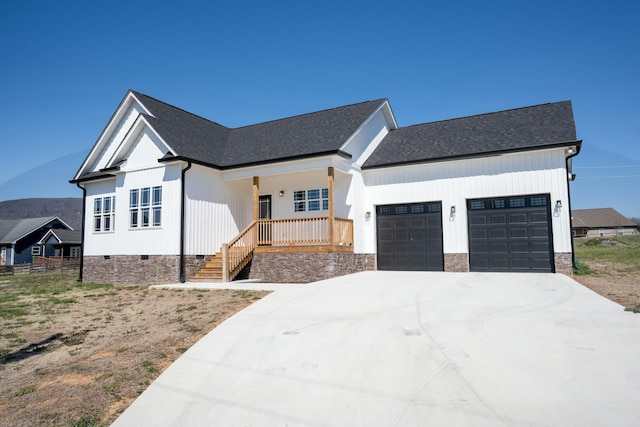 modern inspired farmhouse featuring roof with shingles, covered porch, concrete driveway, a garage, and crawl space