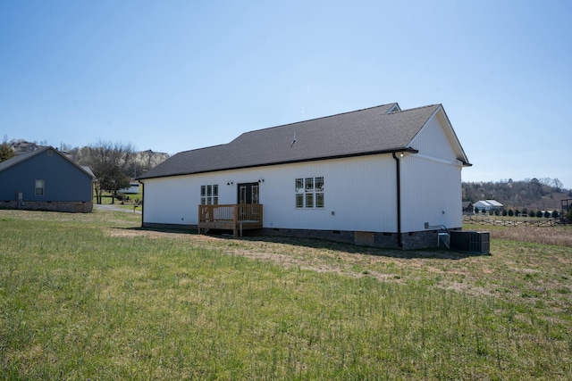 back of property with crawl space, a yard, and roof with shingles