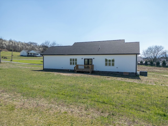 rear view of house with crawl space, a wooden deck, a yard, and a shingled roof