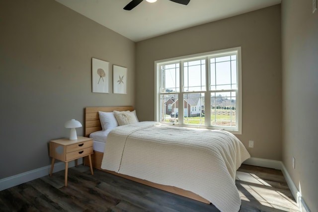 bedroom featuring a ceiling fan, dark wood-type flooring, and baseboards