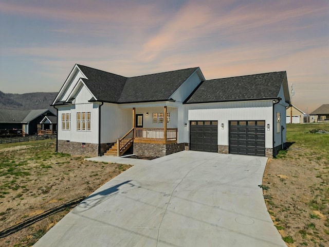 modern inspired farmhouse featuring driveway, a porch, an attached garage, a shingled roof, and crawl space