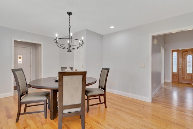 dining space with recessed lighting, baseboards, light wood finished floors, and a chandelier