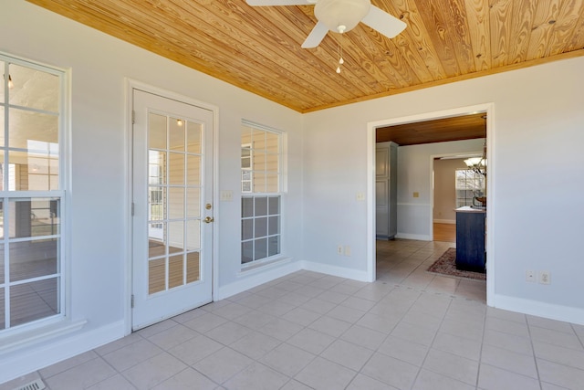 spare room with light tile patterned floors, baseboards, wood ceiling, and a ceiling fan