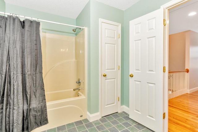 bathroom featuring shower / bathtub combination with curtain, baseboards, and wood finished floors