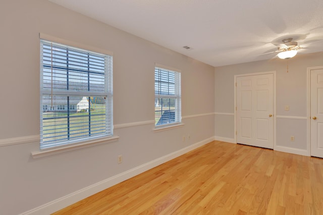 unfurnished room with visible vents, baseboards, a ceiling fan, and light wood finished floors