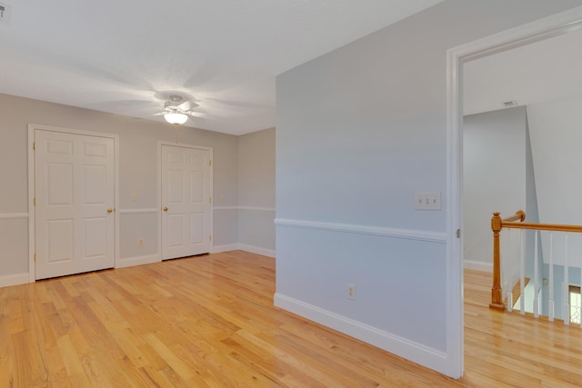 unfurnished room with visible vents, light wood-style flooring, a ceiling fan, and baseboards