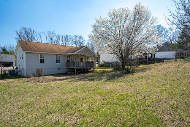 back of house featuring a lawn, a deck, and fence