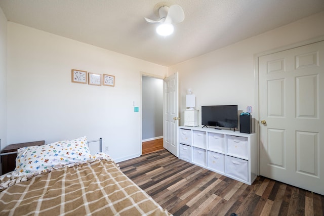 bedroom with baseboards, a textured ceiling, and dark wood-style floors