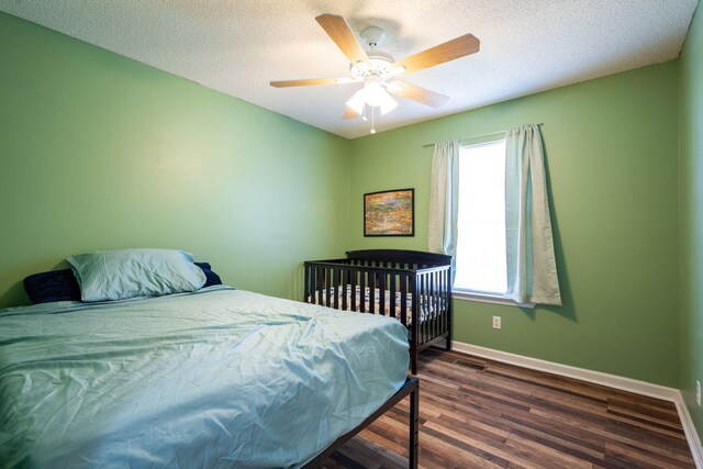 bedroom featuring ceiling fan, wood finished floors, baseboards, and a textured ceiling