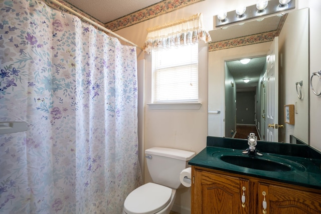 full bathroom featuring vanity, a shower with shower curtain, toilet, and a textured ceiling