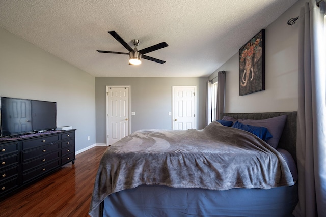 bedroom featuring dark wood-style floors, baseboards, a textured ceiling, and ceiling fan