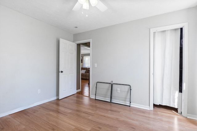 spare room with light wood-style flooring, baseboards, and ceiling fan