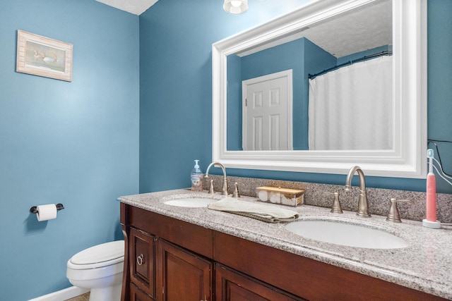 full bath featuring double vanity, toilet, and a sink