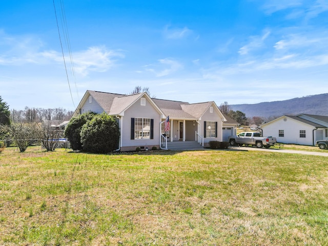 single story home with a mountain view, an attached garage, driveway, and a front lawn