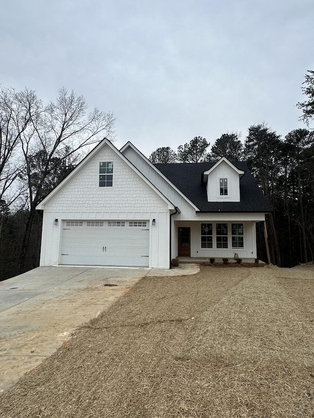 view of front of home featuring an attached garage, driveway, and roof with shingles