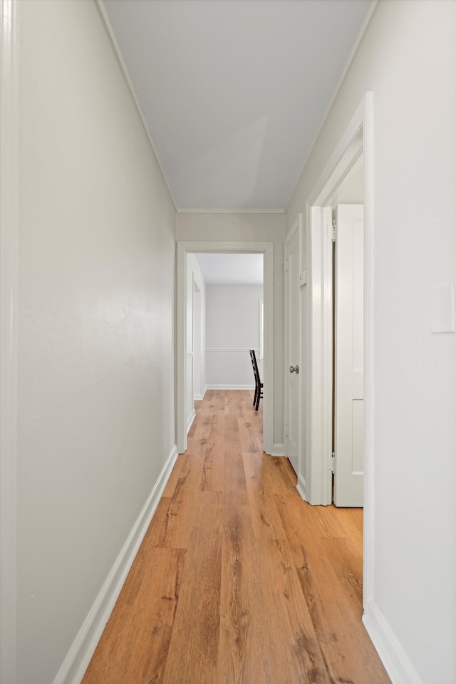 hallway with baseboards and light wood-style floors