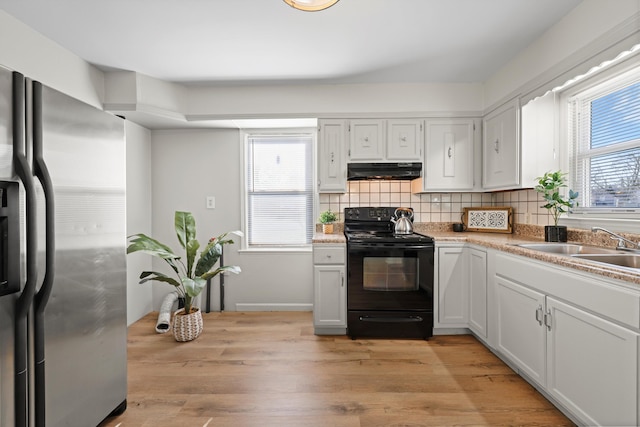 kitchen with plenty of natural light, extractor fan, black range with electric cooktop, stainless steel fridge, and backsplash