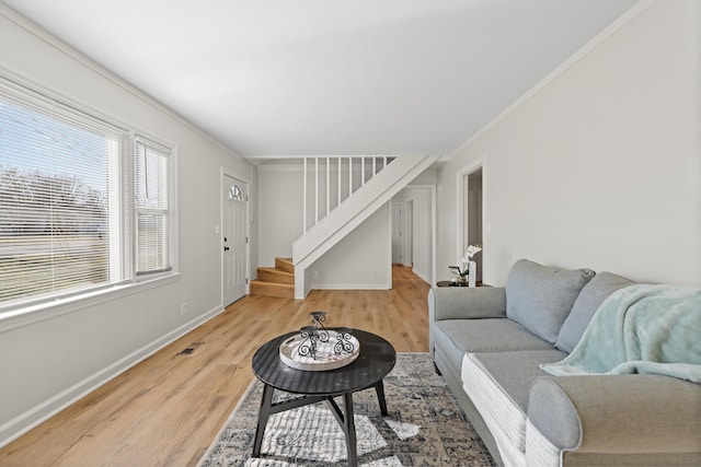 living room featuring visible vents, ornamental molding, wood finished floors, baseboards, and stairs