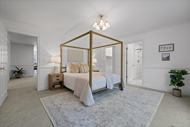 bedroom featuring connected bathroom, crown molding, baseboards, a chandelier, and carpet floors