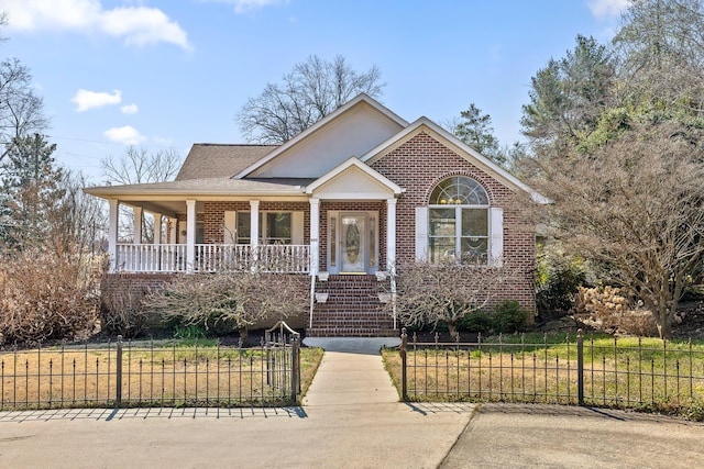 view of front of home featuring a porch, brick siding, and a fenced front yard