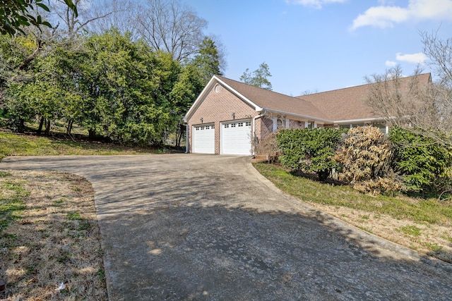 view of home's exterior featuring brick siding, driveway, a shingled roof, and a garage