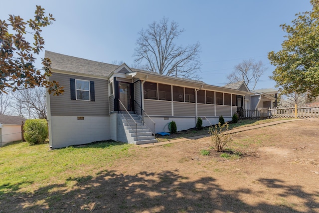 ranch-style house with fence, a front yard, and a sunroom