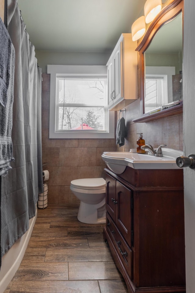 bathroom featuring a wealth of natural light, toilet, tile walls, and vanity