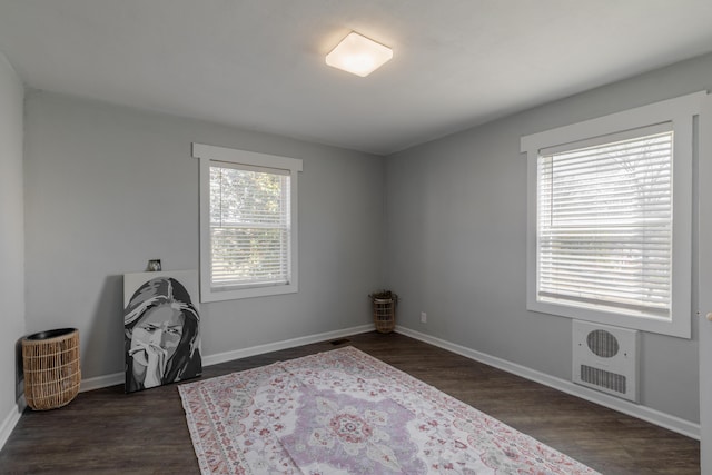 interior space featuring dark wood-type flooring, visible vents, and baseboards