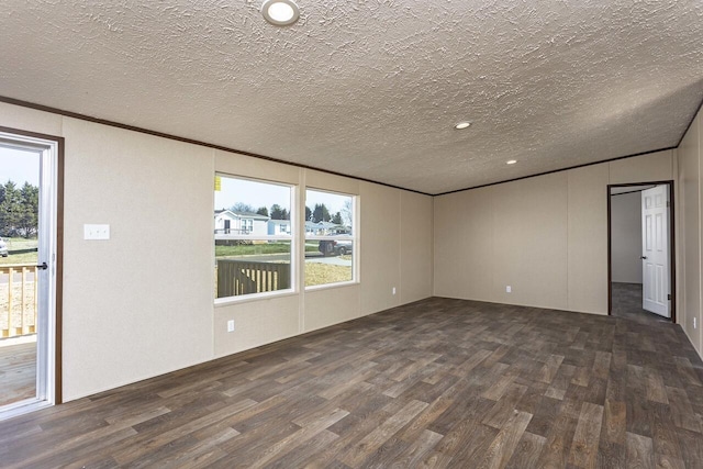 empty room with dark wood-type flooring, ornamental molding, and a textured ceiling