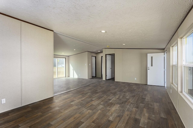 unfurnished room featuring a wealth of natural light, a textured ceiling, wood finished floors, and crown molding