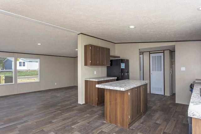 kitchen with dark wood finished floors, light countertops, and freestanding refrigerator