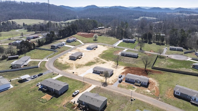 birds eye view of property with a mountain view and a view of trees