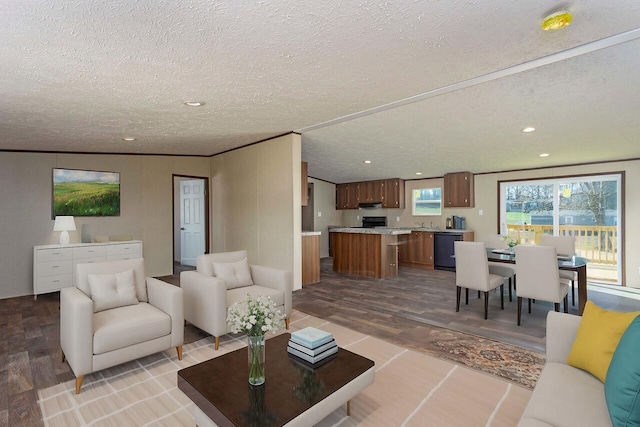 living area with recessed lighting, light wood-style floors, ornamental molding, and a textured ceiling