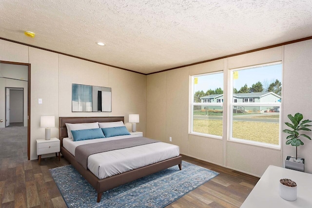 bedroom featuring a textured ceiling, dark wood-type flooring, and ornamental molding