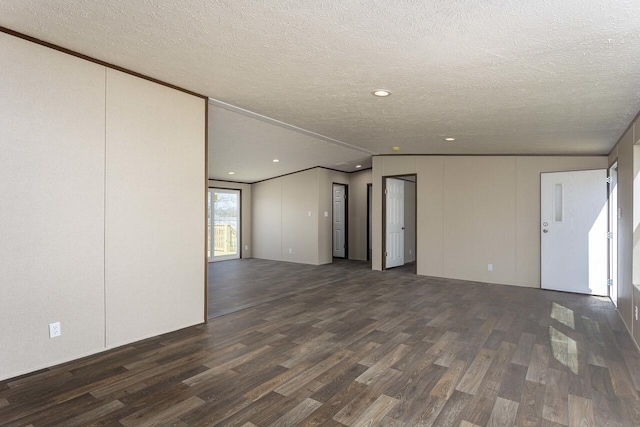 spare room featuring a textured ceiling and dark wood-style flooring