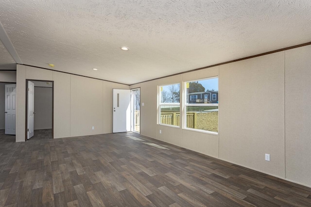 unfurnished room featuring a textured ceiling, dark wood-style floors, and ornamental molding