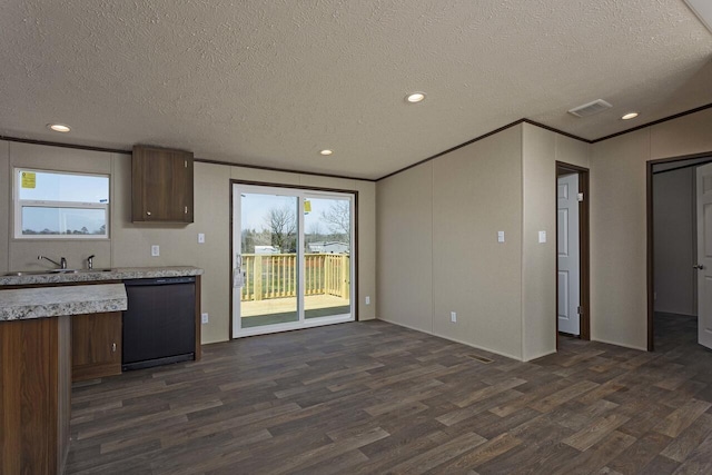 kitchen featuring visible vents, a sink, dark wood finished floors, light countertops, and dishwasher