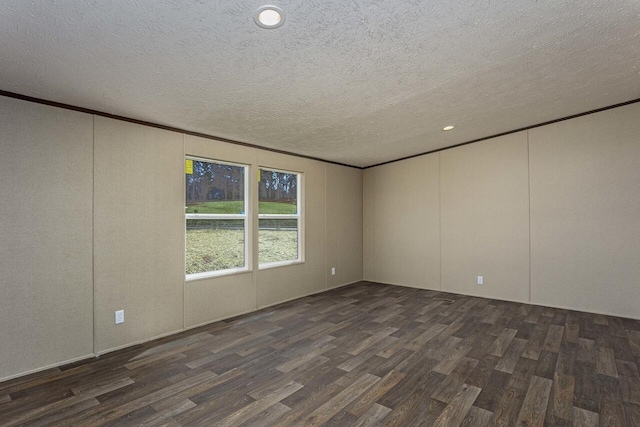 empty room with a decorative wall, ornamental molding, dark wood-style flooring, and a textured ceiling