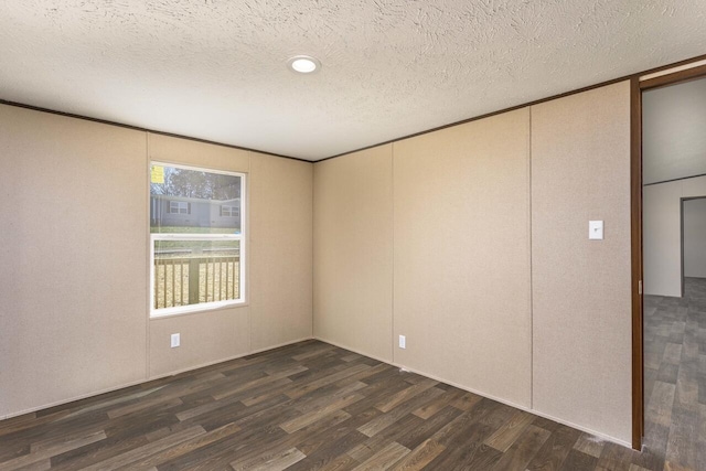 spare room featuring dark wood finished floors and a textured ceiling