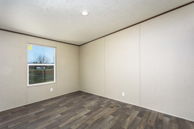 empty room featuring crown molding, wood finished floors, and a textured ceiling