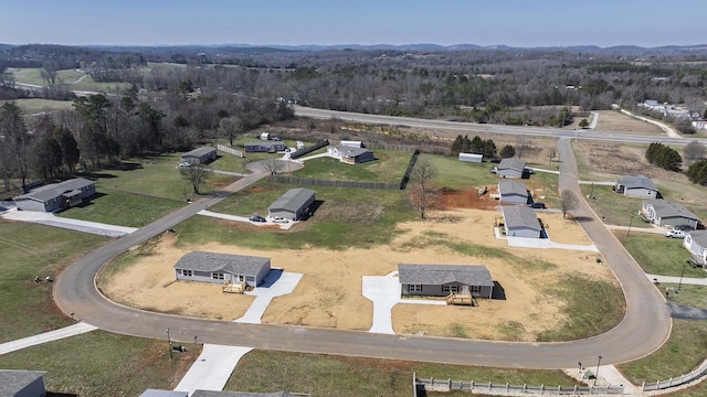 birds eye view of property featuring a rural view and a wooded view