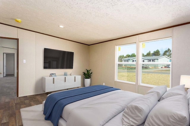 bedroom with wood finished floors, a textured ceiling, and ornamental molding