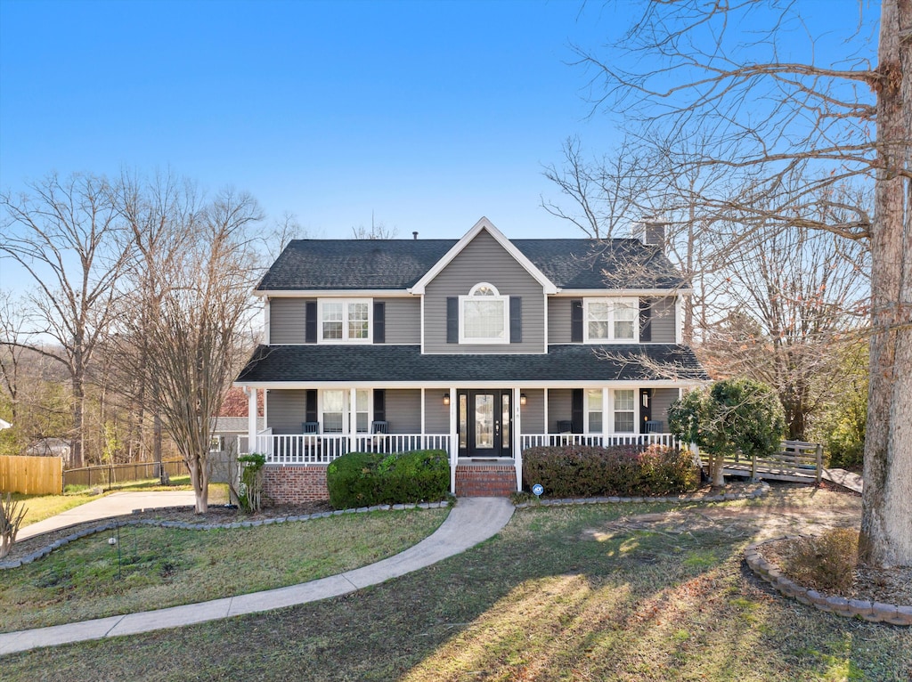 view of front of house featuring a shingled roof, fence, a porch, a front yard, and a chimney