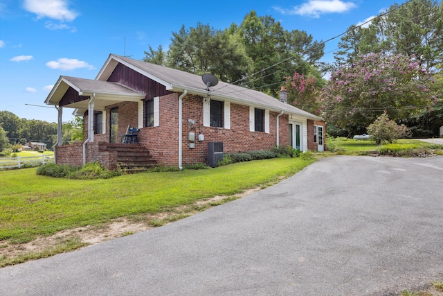 view of home's exterior featuring covered porch, a lawn, brick siding, and a chimney