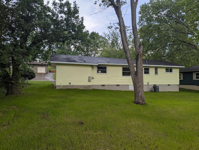 rear view of property with central air condition unit, crawl space, and a lawn